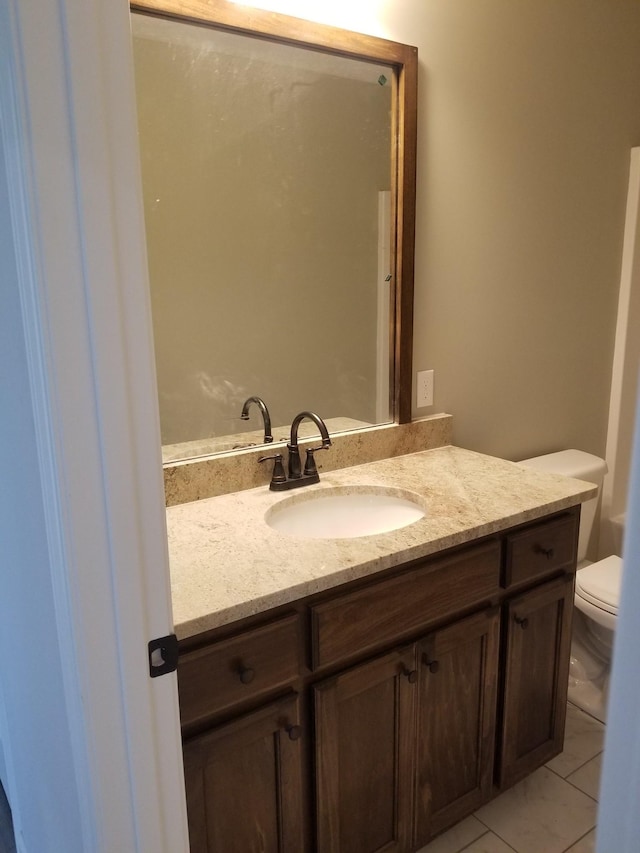 bathroom with tile patterned floors, vanity, and toilet