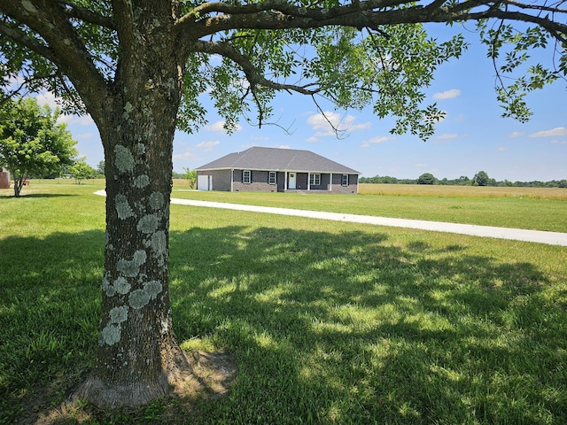 ranch-style home featuring a rural view and a front lawn