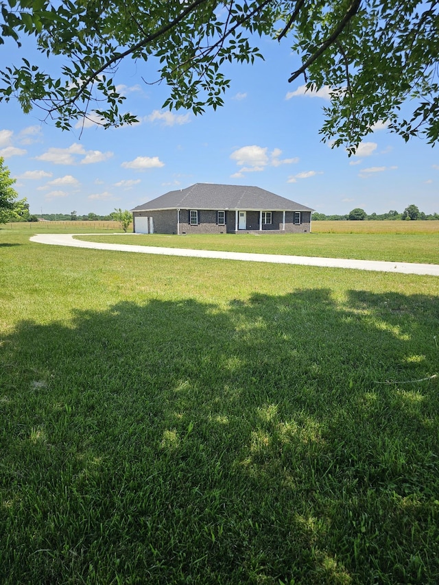 view of front facade with a rural view and a front lawn