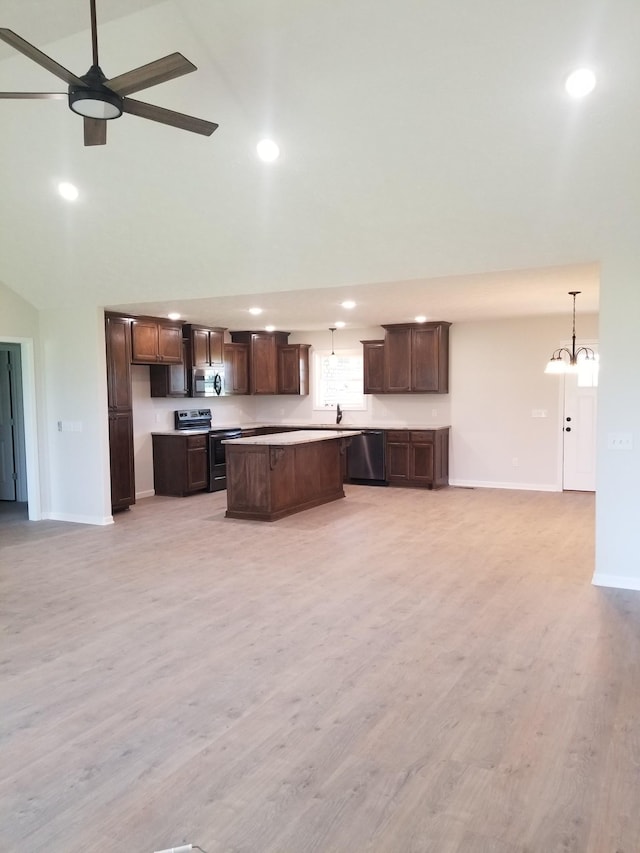 kitchen featuring a center island, high vaulted ceiling, decorative light fixtures, and appliances with stainless steel finishes