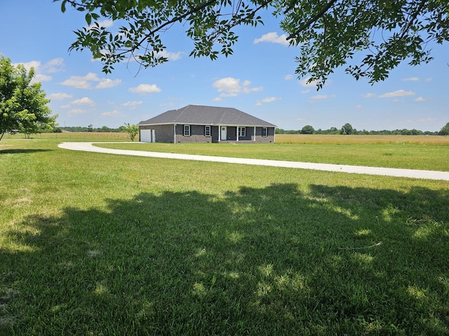 view of front of home with a rural view and a front lawn