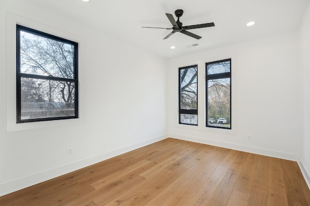 spare room with ceiling fan, light hardwood / wood-style flooring, and a healthy amount of sunlight