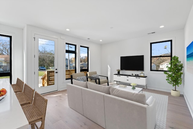 living room featuring plenty of natural light and light hardwood / wood-style floors