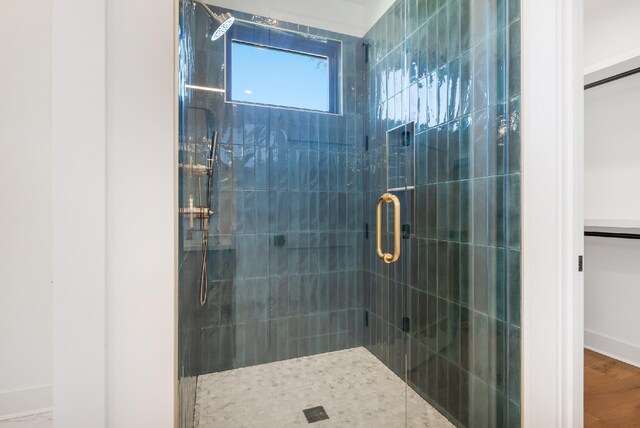 bathroom with hardwood / wood-style flooring and an enclosed shower