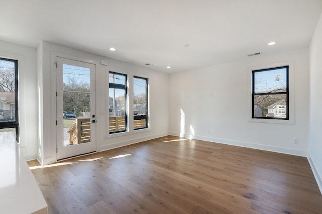 unfurnished room with hardwood / wood-style flooring