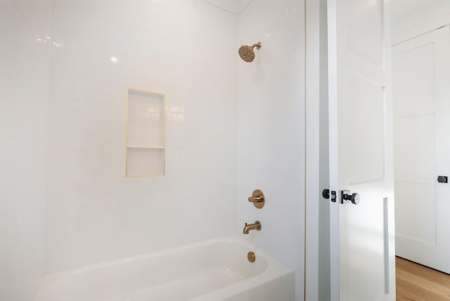 bathroom with wood-type flooring and tiled shower / bath