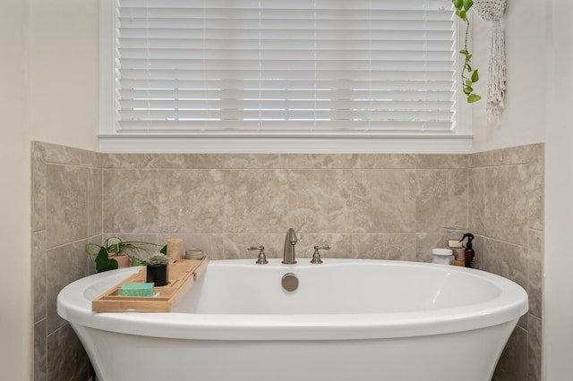 bathroom featuring a tub, plenty of natural light, and tile walls