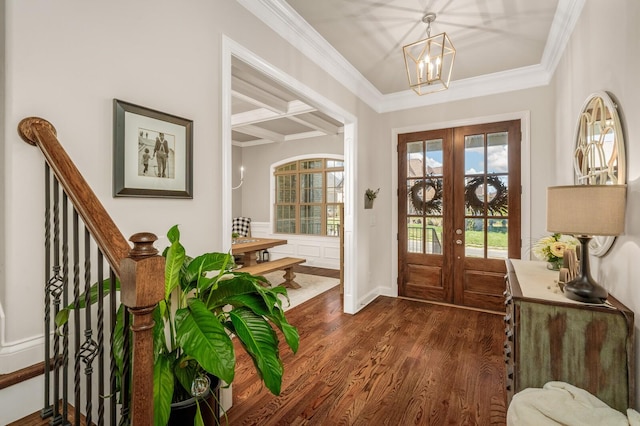 foyer entrance featuring french doors, ornamental molding, coffered ceiling, a notable chandelier, and dark hardwood / wood-style floors