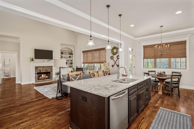 kitchen featuring sink, decorative light fixtures, stainless steel dishwasher, dark brown cabinets, and dark hardwood / wood-style flooring