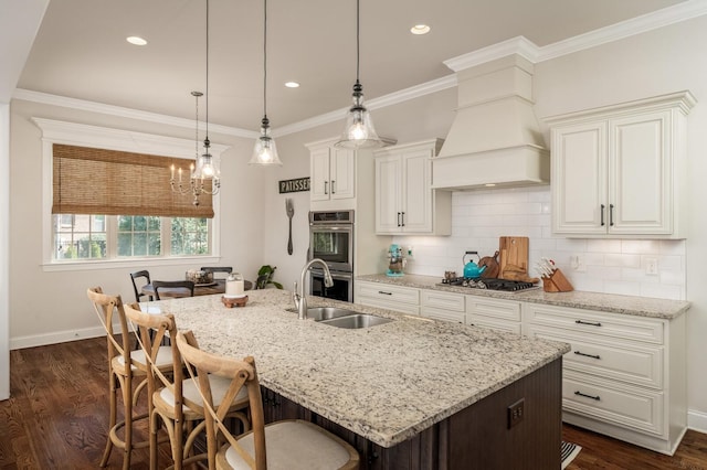 kitchen featuring light stone countertops, dark hardwood / wood-style flooring, a center island with sink, custom range hood, and appliances with stainless steel finishes