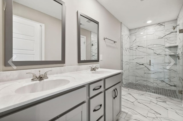 full bath with a sink, a marble finish shower, marble finish floor, and double vanity