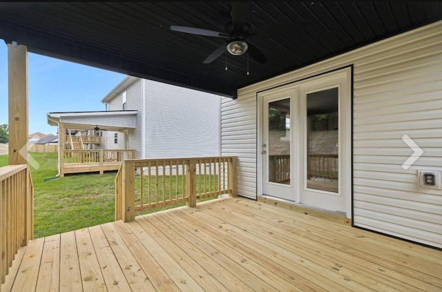 wooden deck featuring a yard and ceiling fan