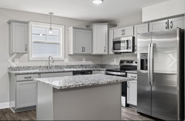 kitchen with a sink, appliances with stainless steel finishes, dark wood-style floors, and gray cabinetry