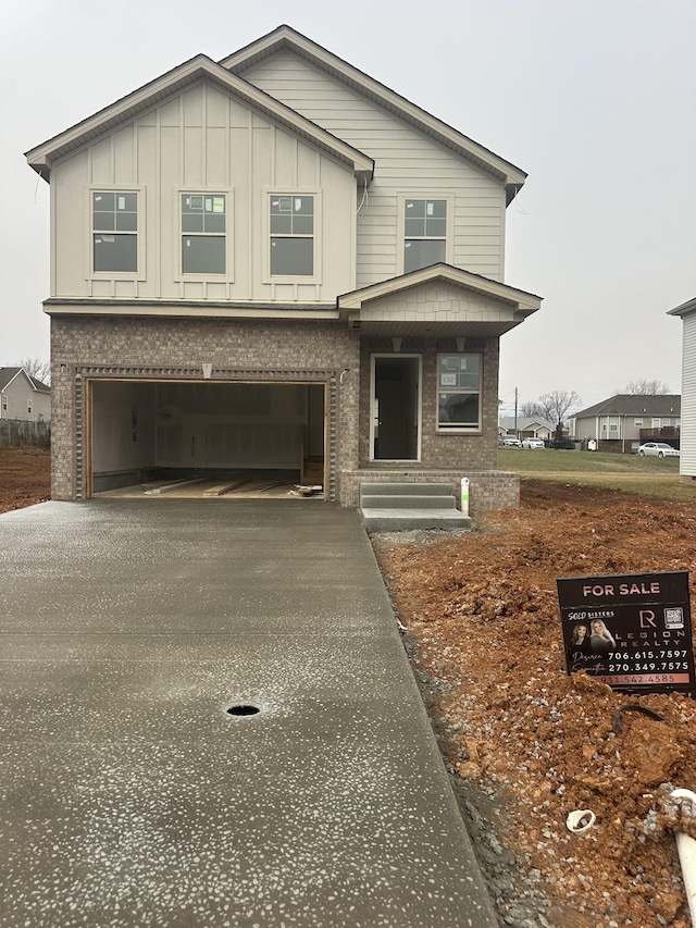 view of front of home with aphalt driveway, an attached garage, and board and batten siding