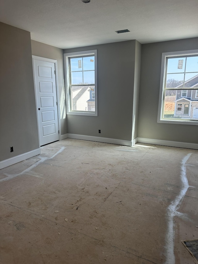 unfurnished room featuring baseboards and visible vents