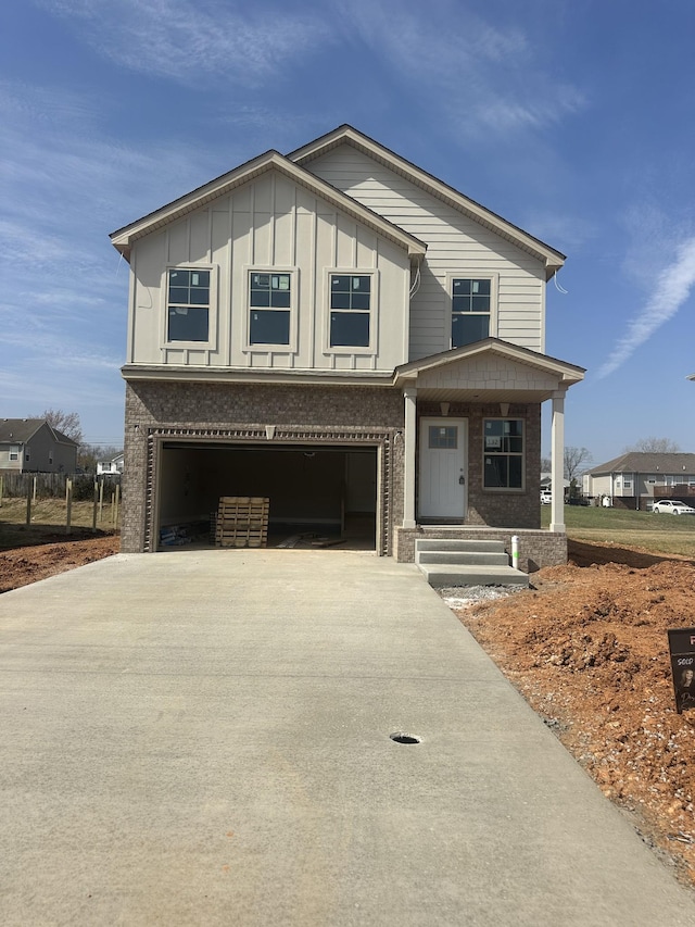 view of front facade with a garage, brick siding, board and batten siding, and concrete driveway