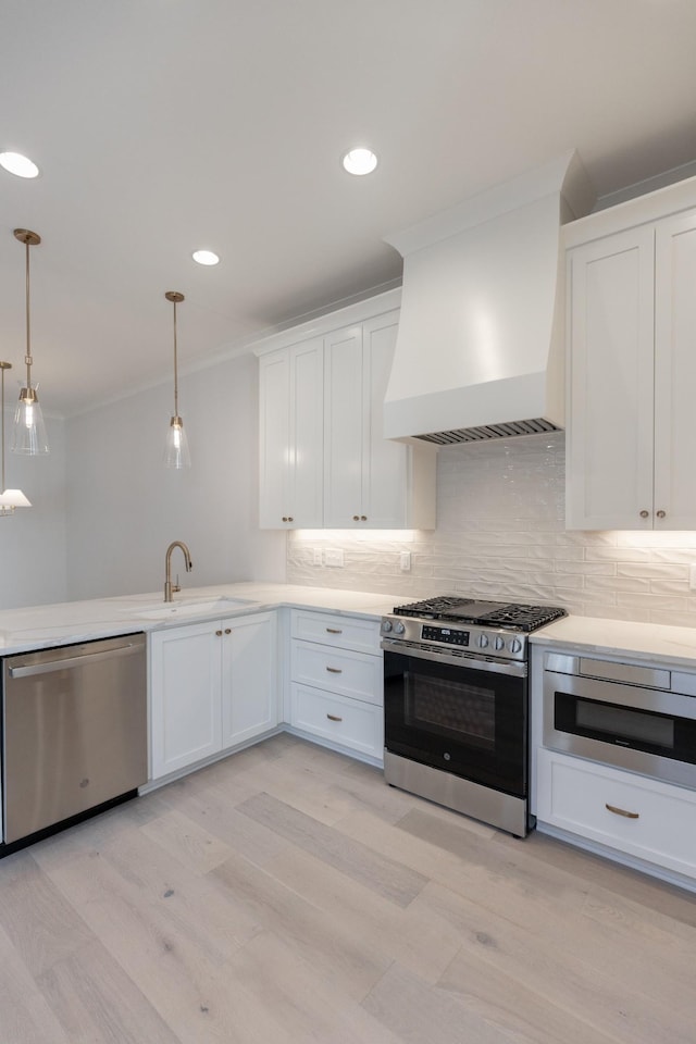 kitchen featuring custom range hood, a sink, stainless steel appliances, white cabinets, and light countertops