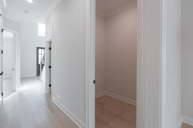 hallway featuring recessed lighting, baseboards, light wood-type flooring, and ornamental molding