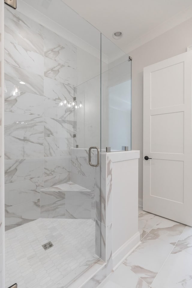 bathroom featuring a shower stall, marble finish floor, and ornamental molding