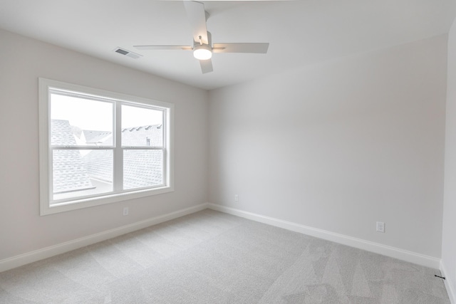 unfurnished room featuring a ceiling fan, light colored carpet, visible vents, and baseboards