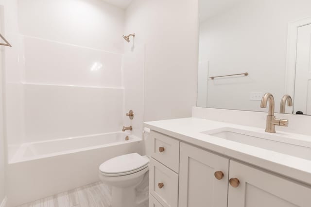 bathroom with toilet, vanity, and  shower combination