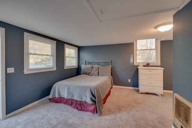 carpeted bedroom with heating unit and multiple windows