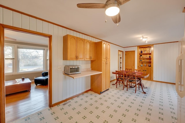 kitchen with built in shelves, ceiling fan, light brown cabinets, light hardwood / wood-style floors, and ornamental molding