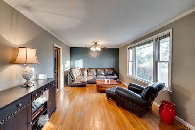 living room featuring crown molding, ceiling fan, and light wood-type flooring