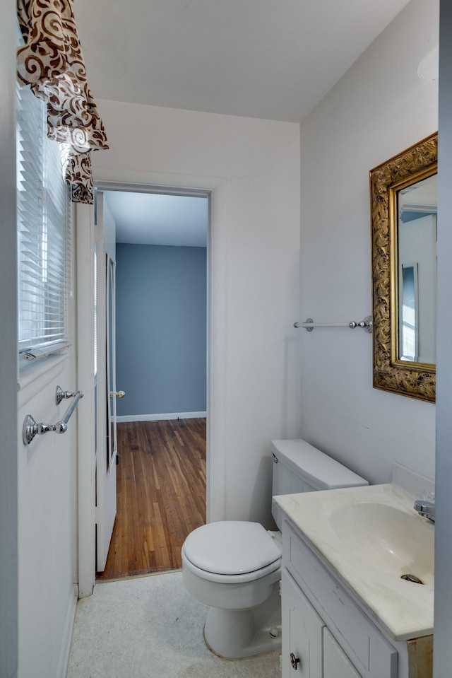 bathroom with vanity, toilet, and wood-type flooring