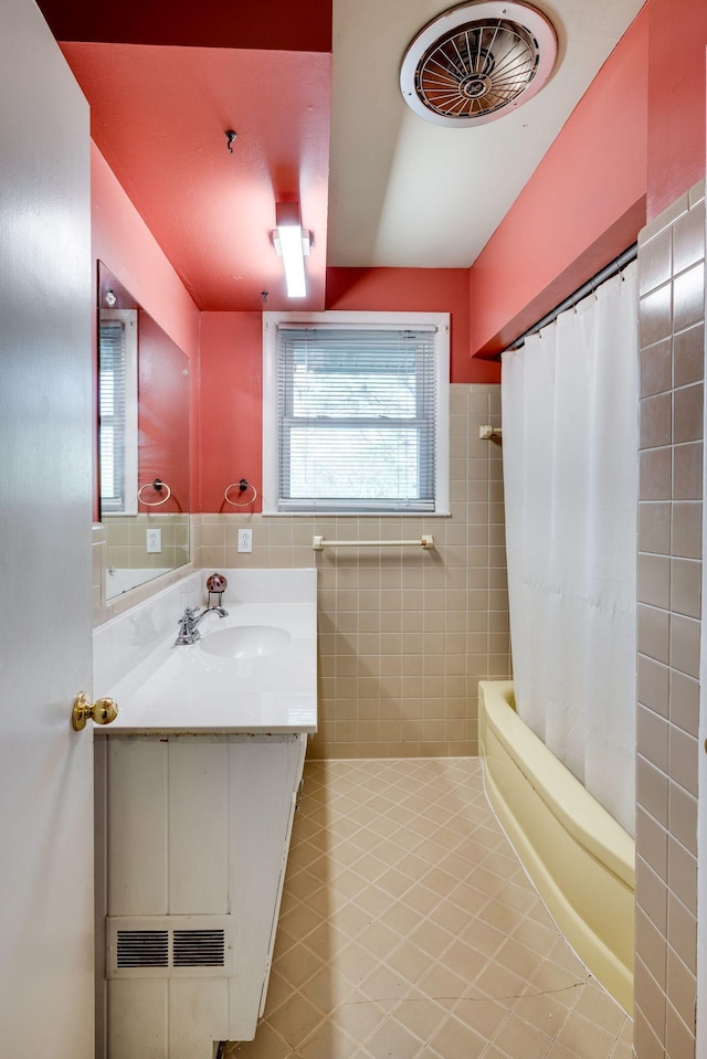 bathroom featuring tile patterned floors, shower / bath combo, tile walls, and vanity