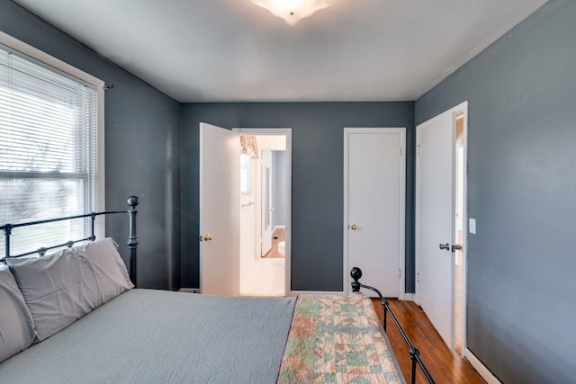 bedroom with hardwood / wood-style flooring and ensuite bath