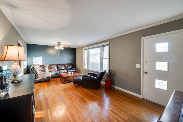 living room with ceiling fan, wood-type flooring, and ornamental molding