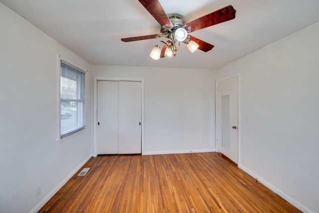 unfurnished bedroom with a closet, ceiling fan, and hardwood / wood-style floors