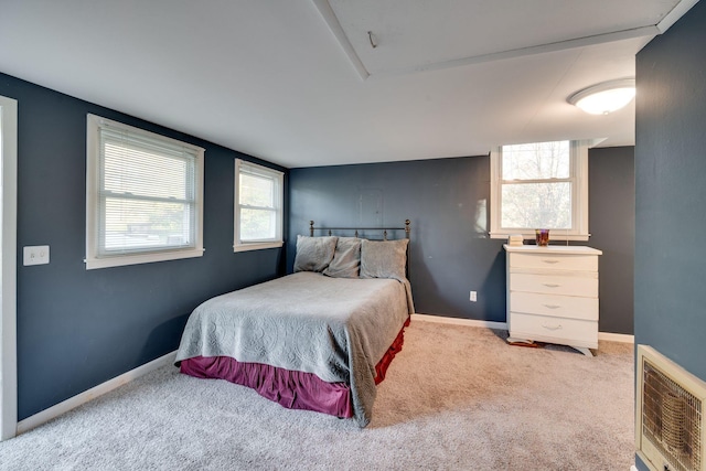 bedroom with carpet, heating unit, and multiple windows