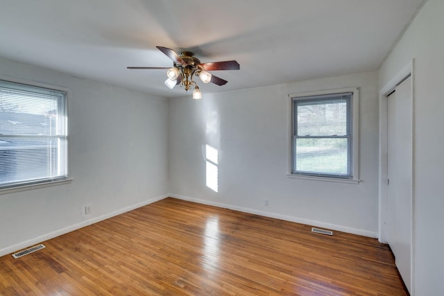 unfurnished bedroom with ceiling fan, wood-type flooring, and a closet