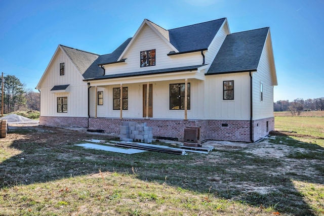 modern inspired farmhouse featuring central AC unit, a porch, and a front yard