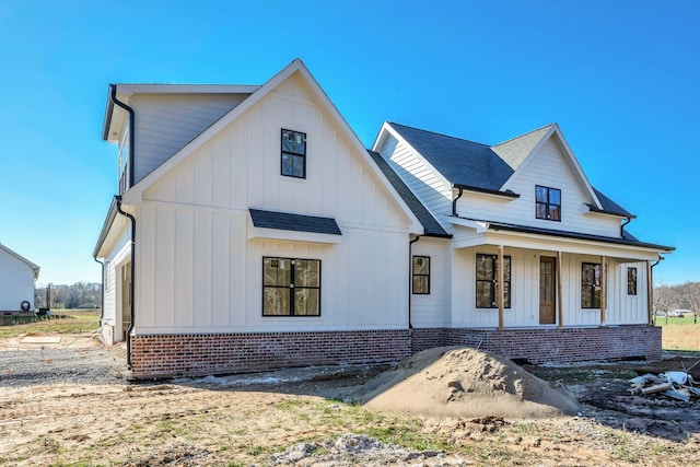 modern farmhouse with a porch and a garage