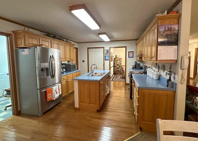 kitchen with appliances with stainless steel finishes, crown molding, sink, hardwood / wood-style flooring, and an island with sink