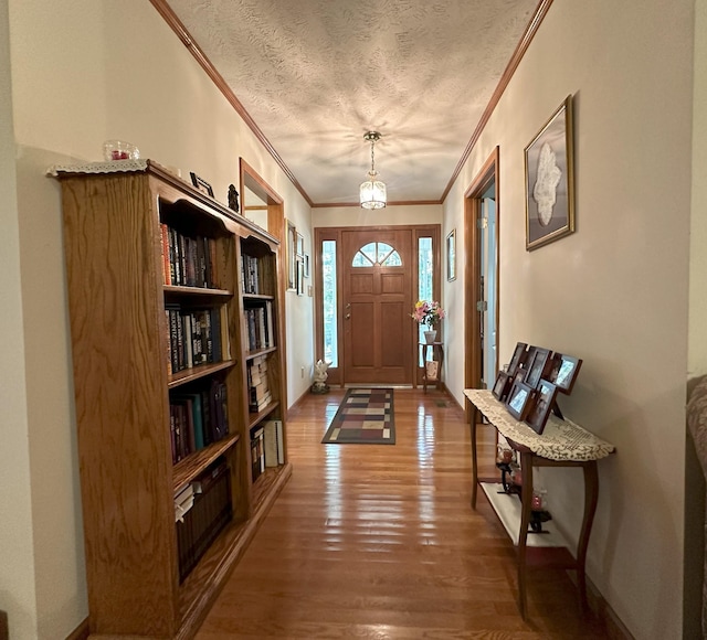 entryway with a textured ceiling, dark hardwood / wood-style floors, and crown molding