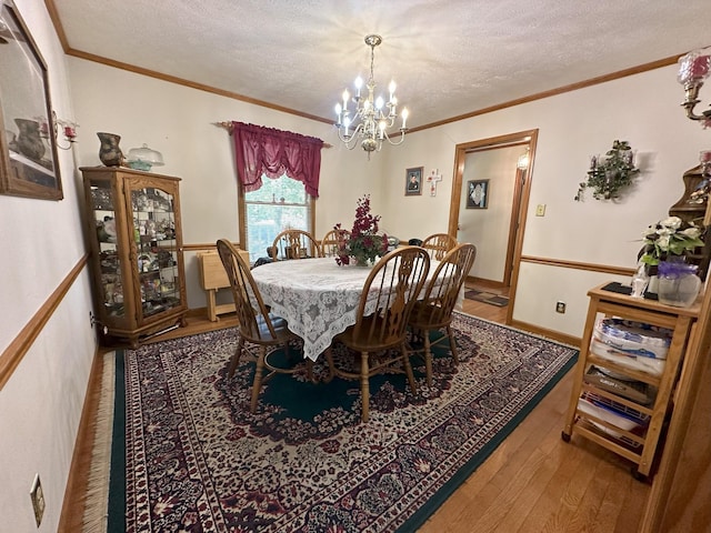 dining room with wood-type flooring, a textured ceiling, and an inviting chandelier