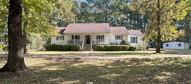 ranch-style house with a porch and a front lawn