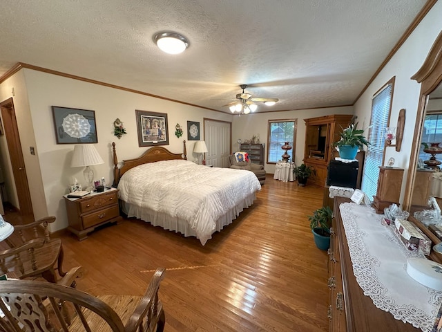 bedroom with ceiling fan, light hardwood / wood-style flooring, a textured ceiling, and ornamental molding