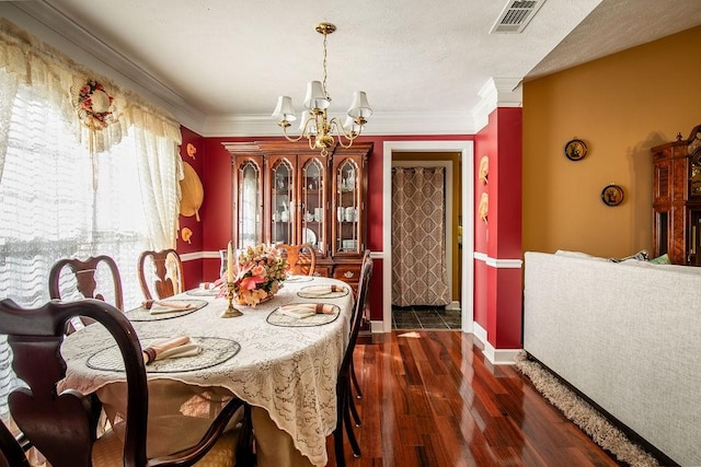 dining area with a chandelier, crown molding, and dark wood-type flooring