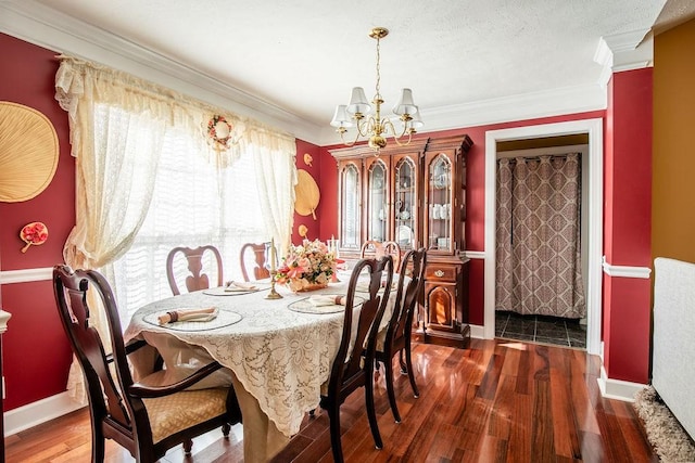 dining area with crown molding, dark hardwood / wood-style flooring, and a notable chandelier