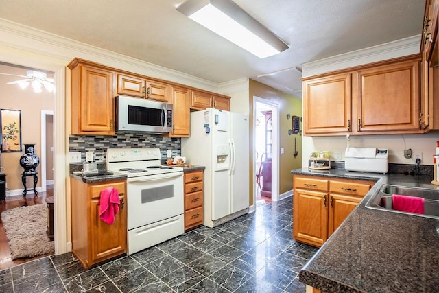 kitchen with crown molding, sink, and white appliances