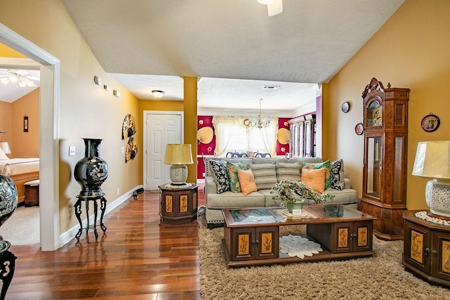 living room featuring a chandelier, a textured ceiling, and dark hardwood / wood-style floors