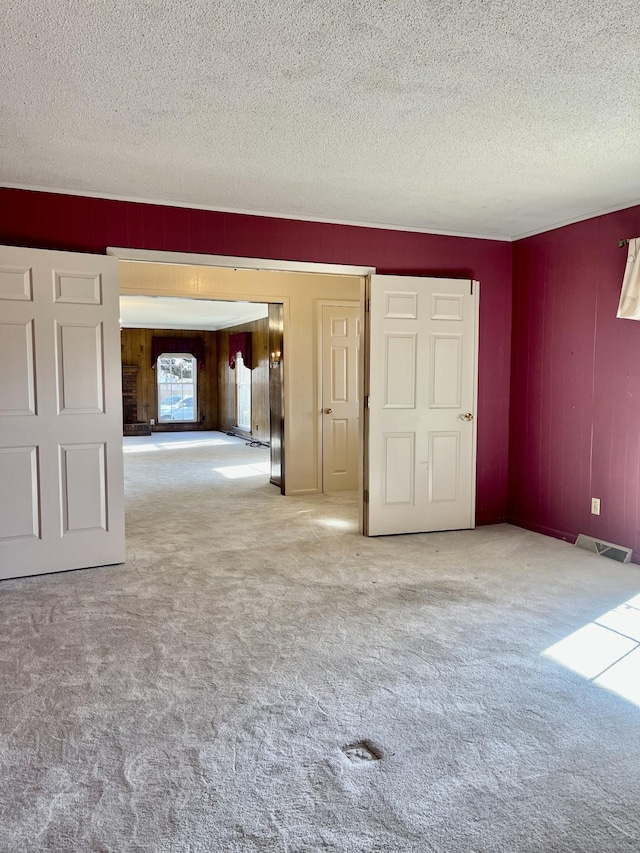 carpeted spare room with a textured ceiling