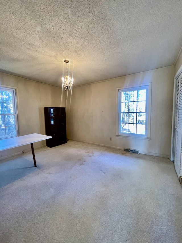 interior space with a textured ceiling and a notable chandelier