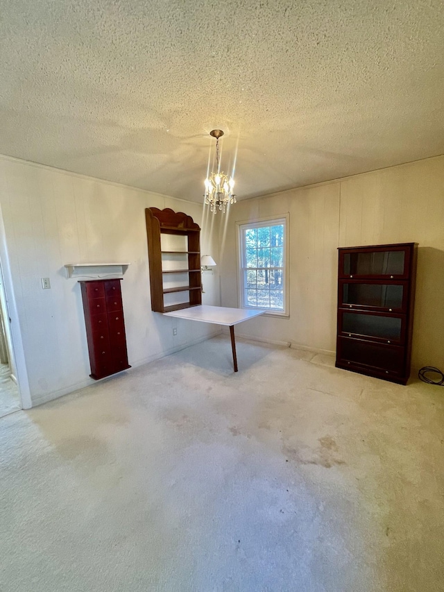 basement with a chandelier, a textured ceiling, and carpet floors