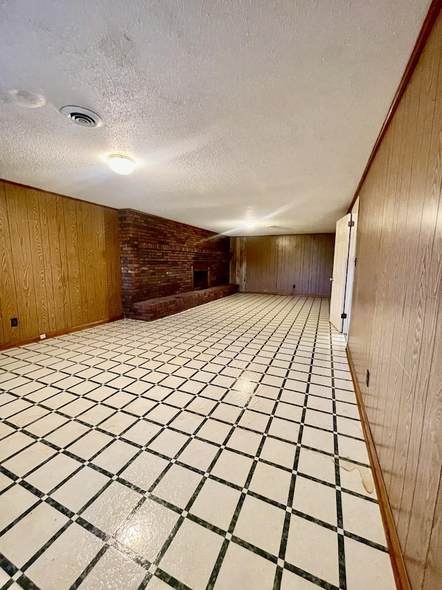 empty room with wooden walls and a textured ceiling